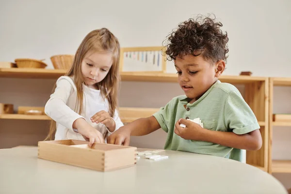 Aprendizaje matemático, niño afroamericano jugando con chica, concepto de escuela montessori, diversos niños - foto de stock