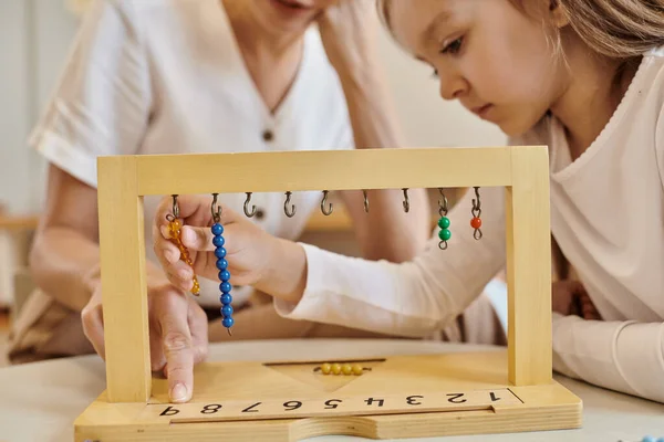 Montessori-Konzept, Kind spielt mit Farbperlentreppe in der Nähe des Lehrers, Holzständer, Nahaufnahme — Stock Photo