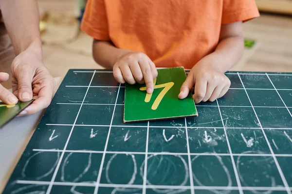 Chica inteligente contando cerca de profesor, pizarra, aprender a contar en la escuela Montessori, recortado — Stock Photo
