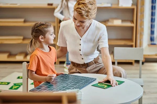 Fille mignonne apprendre par le jeu, mathématiques, comptage, tableau, enseignante, école Montessori — Photo de stock
