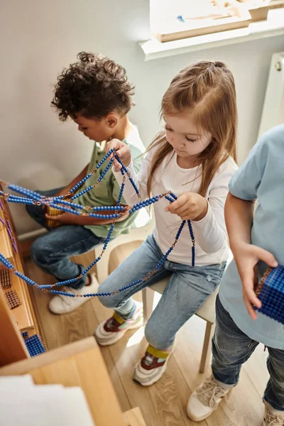 Intelligentes Mädchen, das mit Montessori-Perlen spielt, Mathe lernt, gemischtrassige Kinder, Vielfalt — Stockfoto