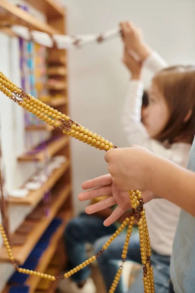 Kid counting yellow beads, Montessori school concept, childhood, education, math, curiosity, study — Stock Photo