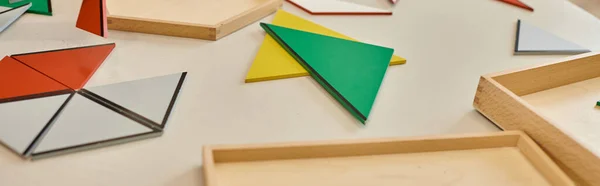 Colorful triangles on table in class of montessori school, banner — Stock Photo
