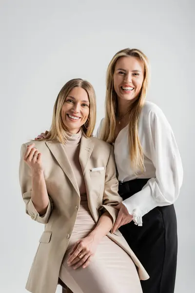 Two happy attractive sisters in formal outfit posing together and smiling, fashion concept — Stock Photo