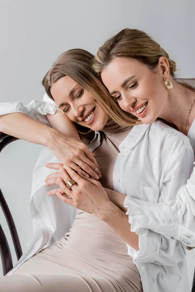Portrait of stylish loving sisters hugging and smiling with closed eyes, style and fashion — Stock Photo