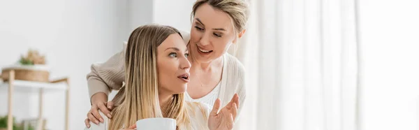 Close up blonde attractive sisters talking and smiling on kitchen background, family bonding, banner — Stock Photo