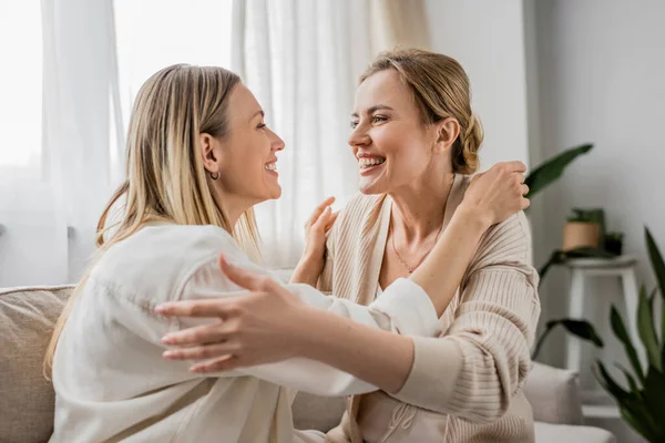Lovely pretty sisters in trendy attire smiling looking at each other and hugging, family bonding — Stock Photo