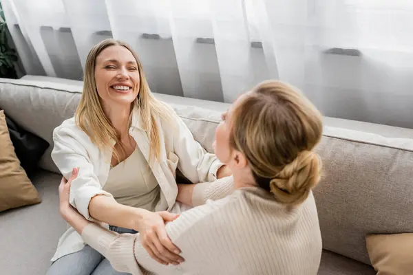 Encantadoras irmãs bonitas na moda desgaste rindo e olhando um para o outro, mão no ombro, ligação — Fotografia de Stock