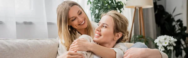 Two trendy blonde sisters hugging warmly on white curtain background, family bonding, banner — Stock Photo