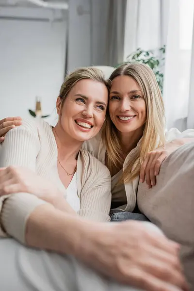 Gros plan de jolies sœurs en vêtements décontractés souriant et serrant chaudement, liens de famille — Photo de stock