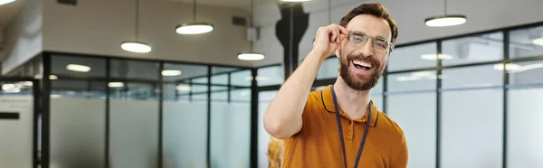 Ritratto dell'imprenditore barbuto felicissimo con gli occhiali che guarda la macchina fotografica in ufficio, banner — Foto stock
