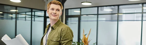 Entrepreneurship concept, smiling businessman with blueprint looking away in modern office, banner — Stock Photo