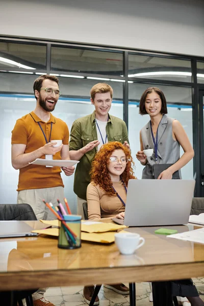 Веселый бизнес-команда улыбается во время видеоконференции на ноутбуке в коворкинг-офисе — стоковое фото