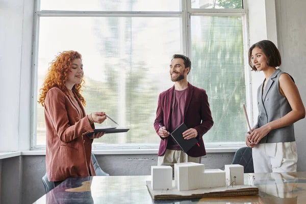 Redhead Designer im Gespräch mit Geschäftspartnern in der Nähe von Gebäude-Modell, Investitionen in Start-up-Projekt — Stockfoto