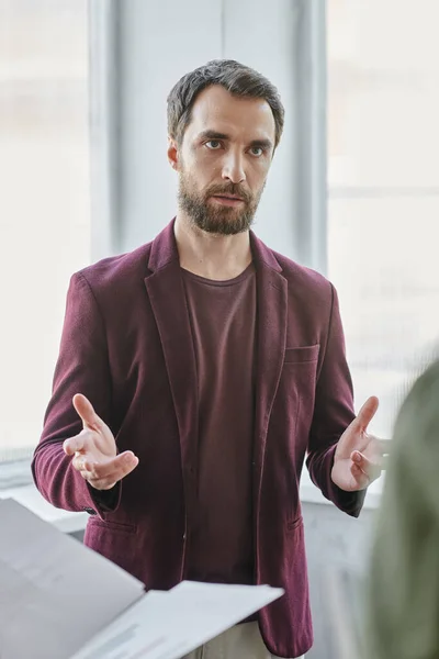 Retrato de sério empresário barbudo gesticulando e falando no escritório — Fotografia de Stock