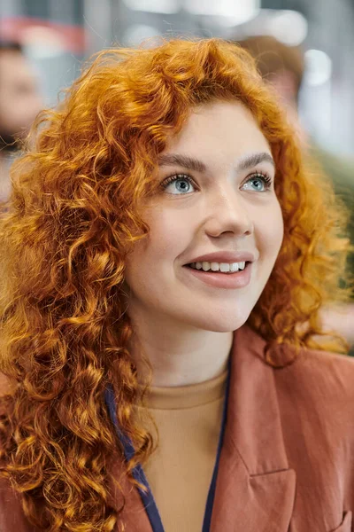 Portrait of pleased redhead woman looking away in office, business success, professional headshot — Stock Photo