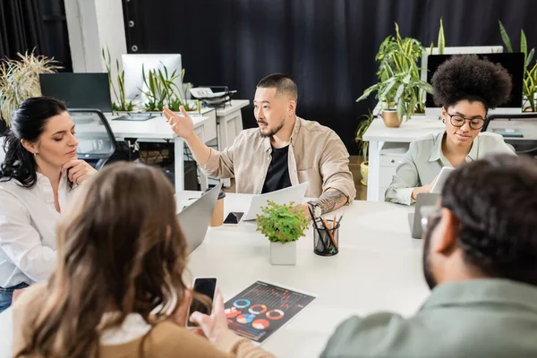 Asian man sharing ideas with team lead and colleagues while working together on startup project — Stock Photo