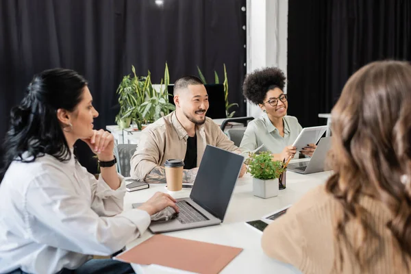 Cheerful multicultural business people discussing project and sharing ideas with team lead in office — Stock Photo