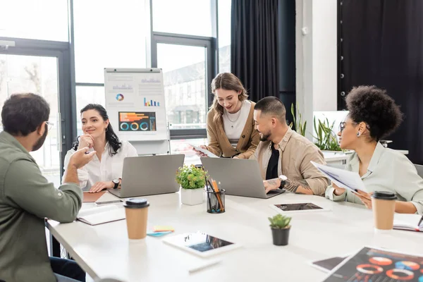 Happy team lead listening ideas of indian coworker near multicultural business people in office — Stock Photo