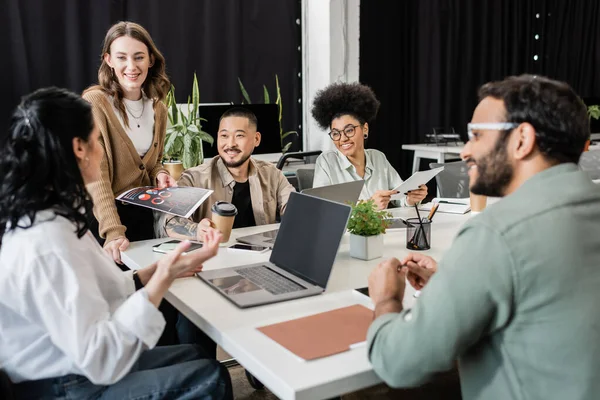 Happy interracial business team looking at team leader on blurred foreground, brainstorming — Stock Photo