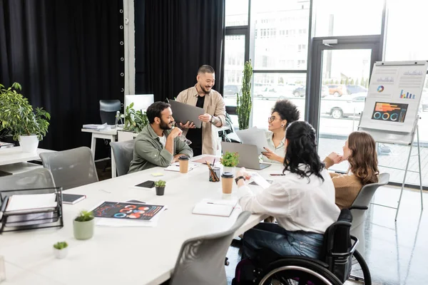 Équipe de démarrage interracial discuter du projet et partager des idées, femme d'affaires en fauteuil roulant — Photo de stock