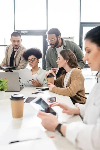 Équipe d'affaires interracial concentrée discutant du projet et partageant des idées dans le coworking moderne — Photo de stock