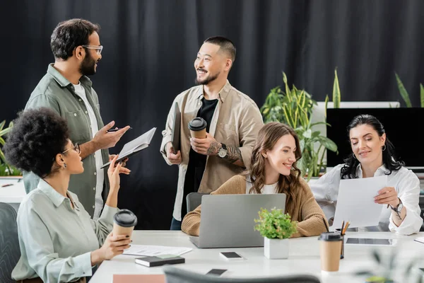 Fröhliches multiethnisches Business-Team, das Ideen generiert und Startup-Projekt im Coworking diskutiert — Stockfoto