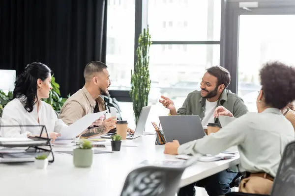 Happy team lead discussing project with interracial startup team in coworking, business people — Stock Photo