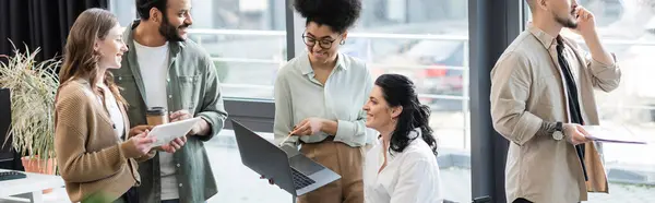 Zufriedene interracial Geschäftsleute, die Geräte verwenden, während sie Startup-Projekte in Coworking planen, Banner — Stockfoto