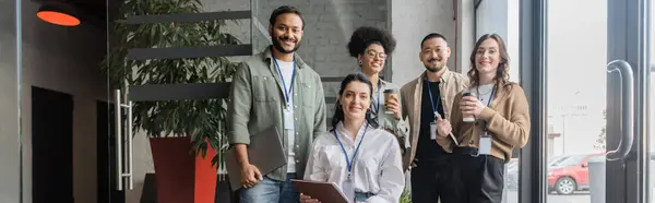 Team di startup diversificata guardando la fotocamera e posa in ufficio, banner di uomini d'affari interrazziale — Foto stock