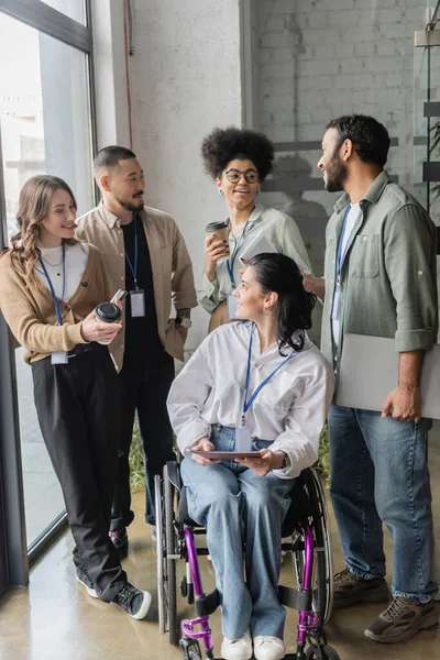 Group shot of diverse startup team looking at each other in office, wheelchair user, inclusion — Stock Photo