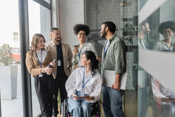 Grupo tiro de feliz equipe diversa olhando uns para os outros no escritório, usuário de cadeira de rodas, inclusão — Fotografia de Stock