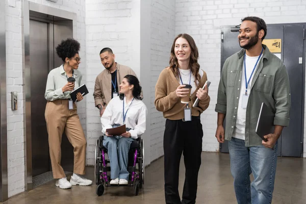 Inclusión y diversidad, equipo creativo multiétnico de pie juntos ascensores de oficinas pulcros en la sala - foto de stock