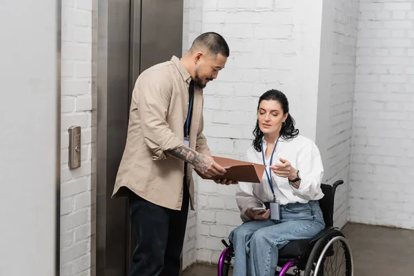 Inclusão, asiático empresário discutir startup plano com deficiente mulher perto de escritório elevadores — Fotografia de Stock