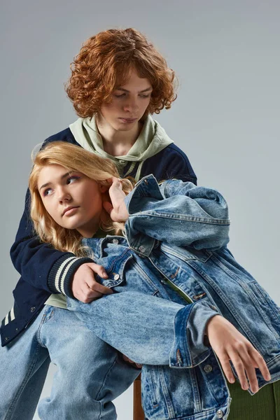 Модна і блондинка дівчина-підліток дивиться далеко від рудого хлопця на сіру, молодіжну моду і стиль життя — стокове фото