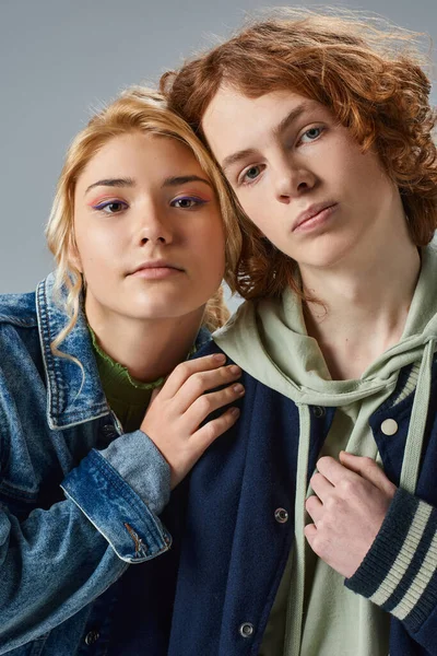 Portrait of teenage models in trendy casual attire looking at camera on grey, friendship and unity — Stock Photo