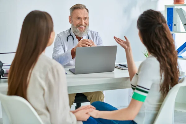 Lgbt couple having appointment and talking to doctor, holding hands, in vitro fertilization concept — Stock Photo
