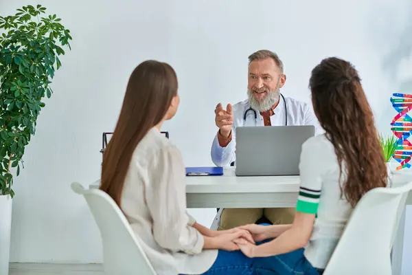 Loving lgbt couple holding hands while listening to gynecologist at his office, ivf concept — Stock Photo