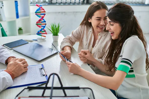 Freudiges lesbisches Paar hält Händchen und betrachtet Ultraschall, Konzept der In-vitro-Fertilisation — Stockfoto