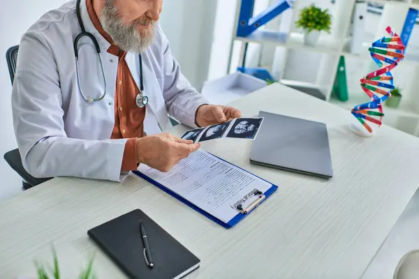 Cropped view of smiley grey bearded gynecologist looking attentively at his patient ultrasound — Stock Photo