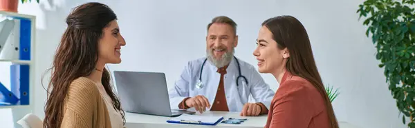 Feliz casal lésbico olhando alegremente um para o outro durante a consulta médica, ivf conceito, banner — Fotografia de Stock