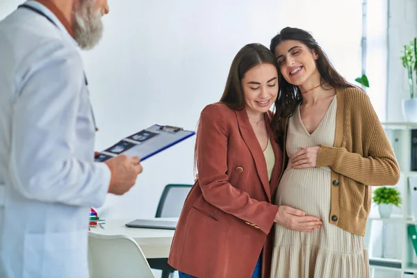Abgeschnittene Ansicht von Lesben, die Schwangerschaftsbauch und Arzt mit Ultraschall umarmen und berühren, ivf concept — Stockfoto