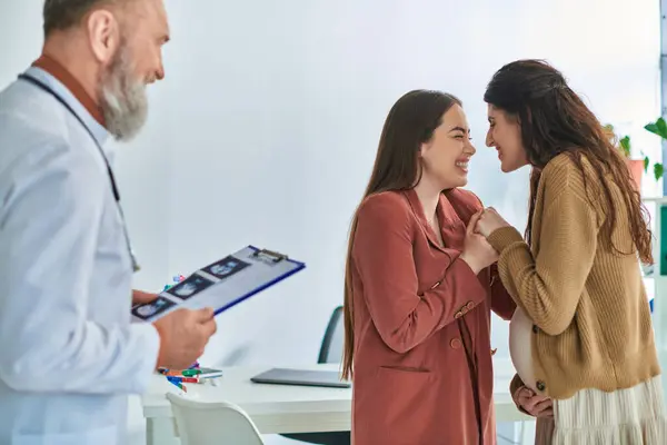 Happy lesbian couple holding hands warmly and smiling at each other, in vitro fertilizing concept — Stock Photo