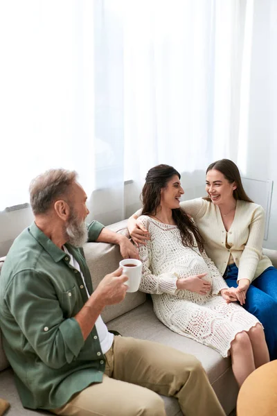 Father paid visit to his lesbian daughter and her partner, talking and sitting on sofa, ivf concept — Stock Photo