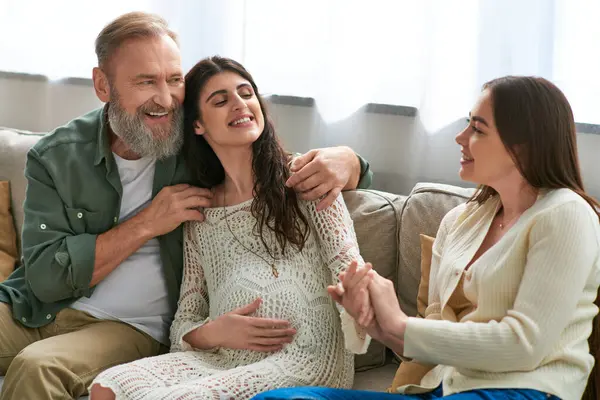 Père étreignant sa fille lesbienne enceinte qui se tient la main avec son partenaire, concept ivf — Photo de stock