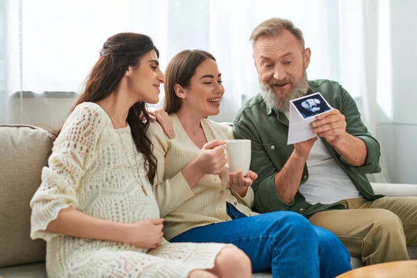 Glücklicher Vater mit Ultraschall des Babys seiner Tochter, die es ihrem Partner zeigt, ivf concept — Stockfoto