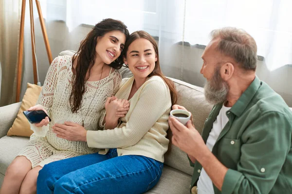 Grey bearded father talking to his cheerful pregnant daughter and her partner, ivf concept — Stock Photo