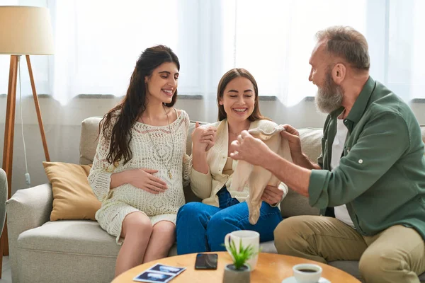 Веселий батько приніс вагітній дочці та її партнерові сингл для їхньої дитини, концепція IVf — стокове фото