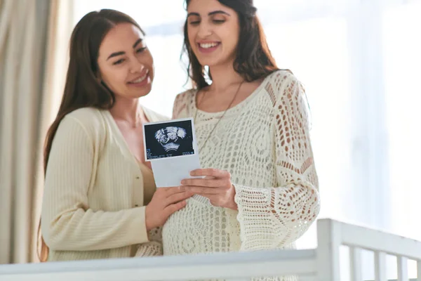 Fröhliches lgbt-Paar steht neben Krippe und betrachtet Ultraschall ihres Babys, ivf concept — Stockfoto