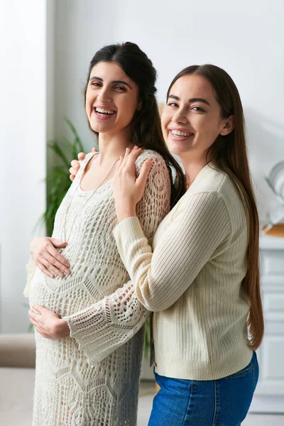 Happy expecting lesbian couple hugging warmly and smiling at camera, in vitro fertilisation concept — Stock Photo